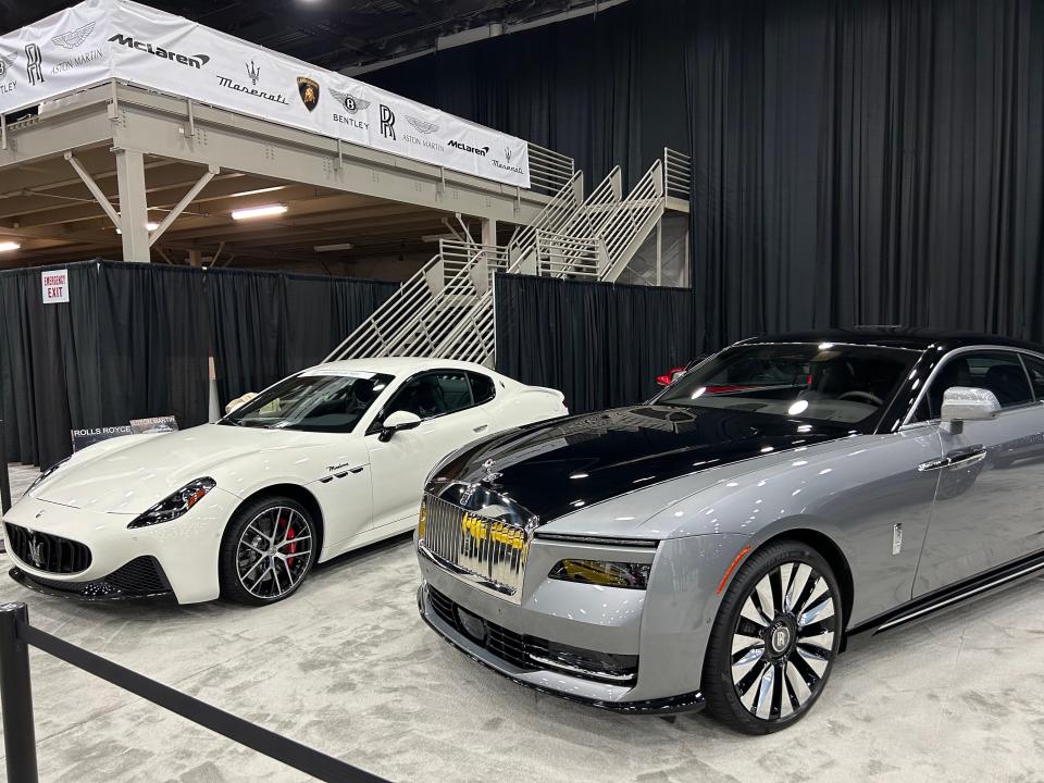 A white vehicle and a silver vehicle sit next to each other on a light carpet.