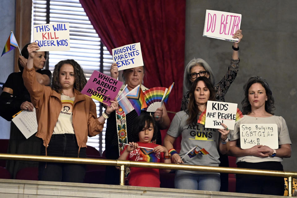 Protesters hold signs in the House gallery against Rep. Mary Littleton, R-Dickson, bill that would require parents are notified of a student's gender identity or intention to transition to a gender different from the person's sex at birth during a legislative session Monday, April 15, 2024, in Nashville, Tenn. (AP Photo/Mark Zaleski)