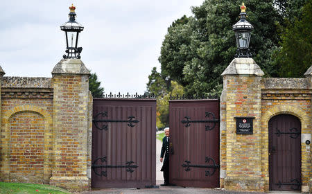 A worker opens one of the gates to Windsor Castle a day ahead of the royal wedding between Princess Eugenie and Jack Brooksbank in Windsor, Britain, October 11, 2018. REUTERS/Dylan Martinez