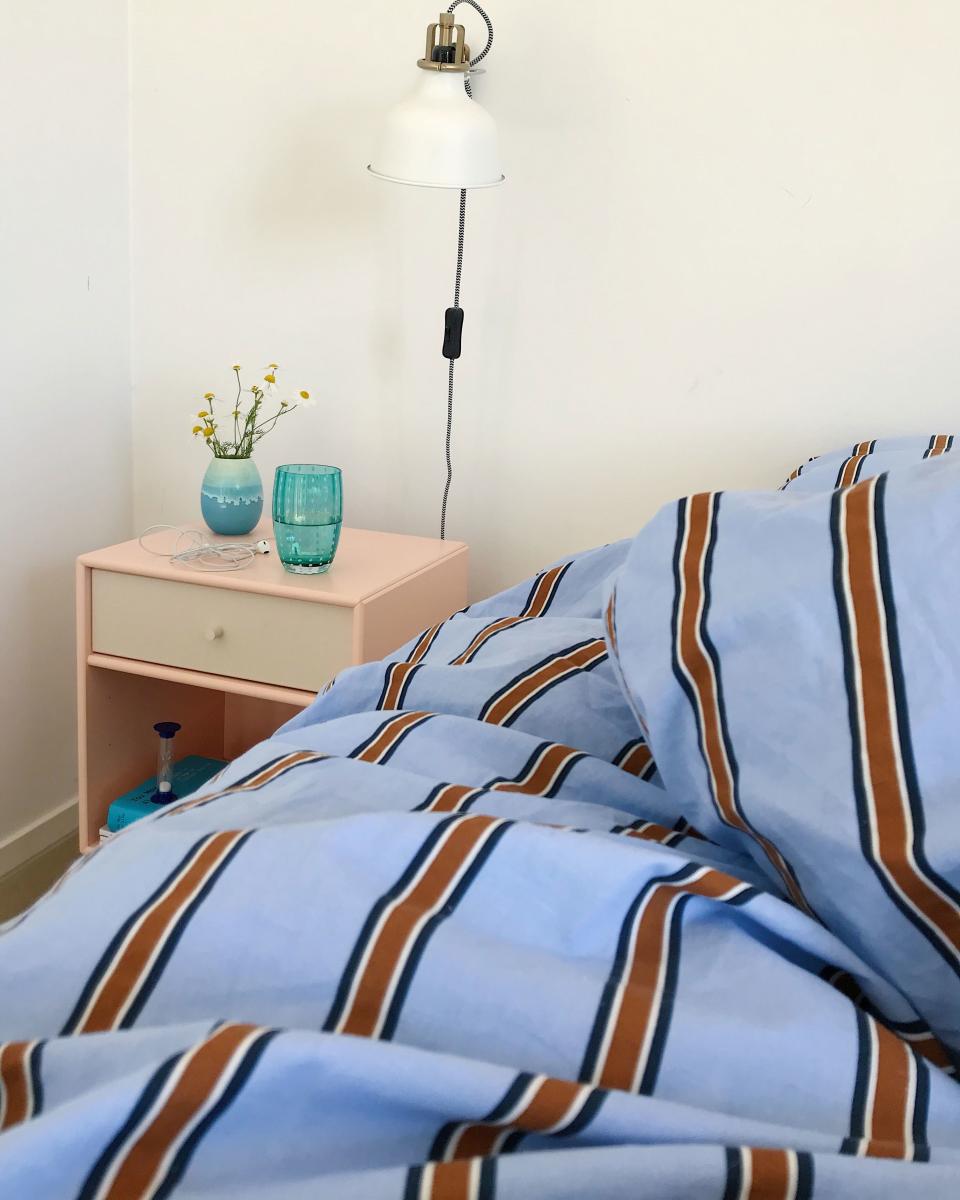 Go for unexpected color combos: “I tend to pick warm pastels like dusty blues and pinks to make the space inviting,” says Lisbeth. “Then I look for something that will add contrast, like a bright turquoise vase or a stripe.” In her bedroom, Lisbeth paired a soothing blush Montana Furniture nightstand with menswear-inspired H&M Home bedding. How to get the look? Choose colors opposite each other on the color wheel, then pick a hue a couple notches to either side for a twist.