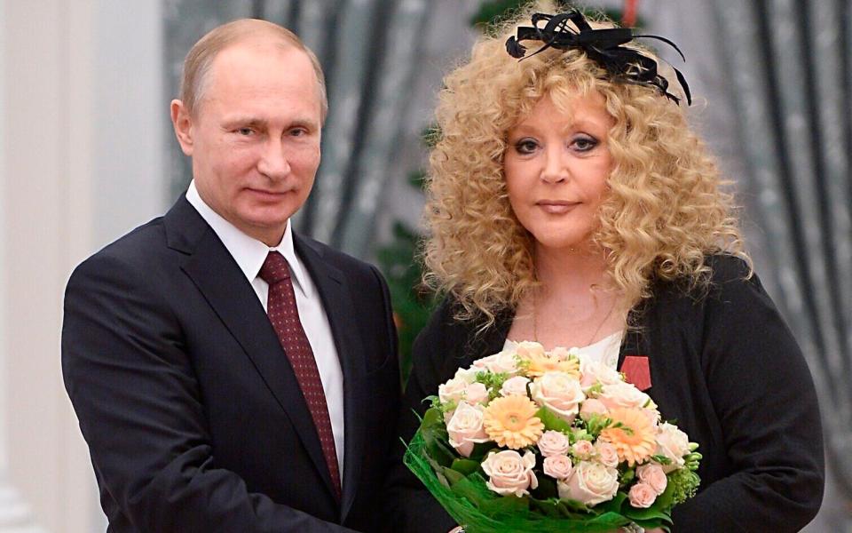 Russian President Vladimir Putin, left, and Russian pop singer Alla Pugacheva pose for a photo during an awards ceremony in Moscow's Kremlin in Moscow, Russia, Monday, Dec. 22, 2014