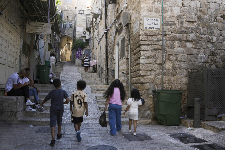 People walk by the house where the Palestinian Ghaith-Sub Laban family lives in the Old City of Jerusalem, Saturday, June 24, 2023. The family has battled Israeli attempts to force them out for the past 45 years. The campaign ended this spring, when the Israeli Supreme Court struck down their final appeal in favor of Jewish settlers contending they violated the lease. Now, Israeli authorities have ordered the eviction of the family to take place by July 13. (AP Photo/Mahmoud Illean)