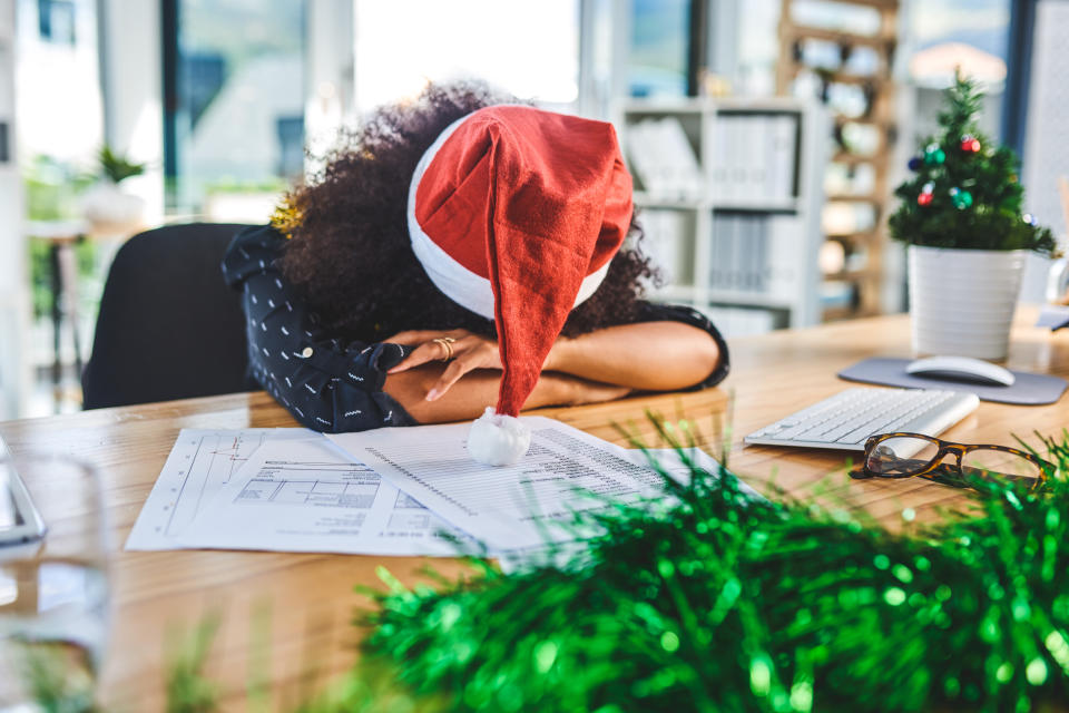 Cropped shot of an attractive young businesswoman wearing christmas decorations and sleeping on her desk in the office