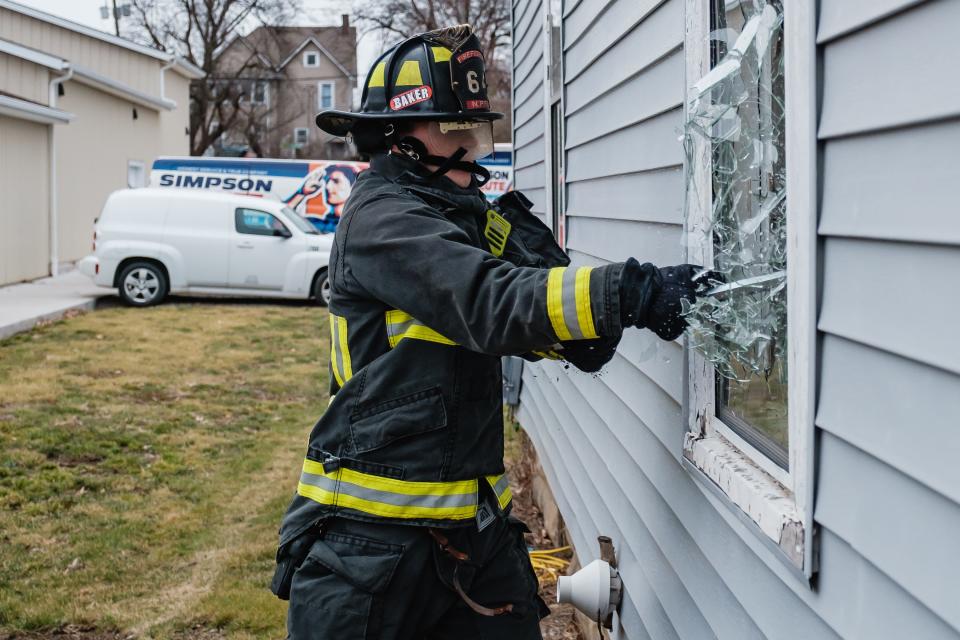 New Philadelphia firefighter Hunter Host practices breaking out a ground-level window using a halligan tool during search and rescue training exercises at a donated vacant home on West High Avenue in New Philadelphia.