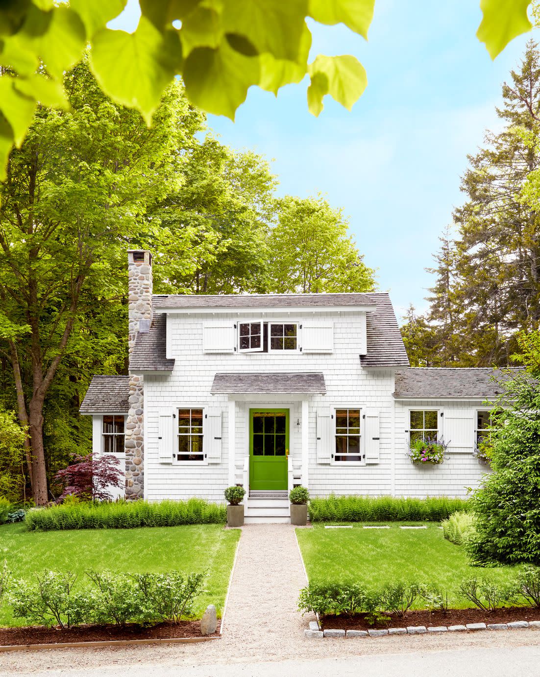 shingled white cottage with green front door