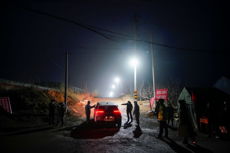 Security members keep watch at an entrance to the Hushan gold mine, where workers are trapped underground after the January 10 explosion, in Qixia