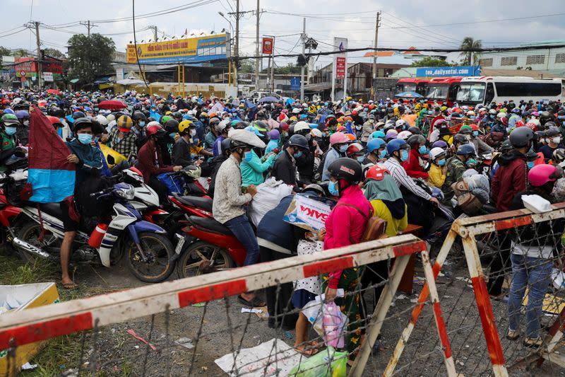 People planning to return to their hometowns wait at a checkpoint to leave Ho Chi Minh