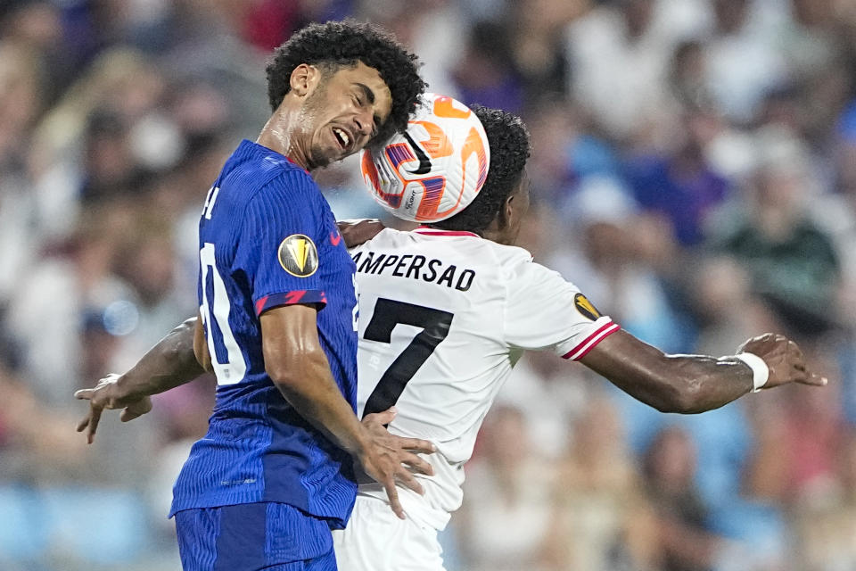 United States defender Jalen Neal heads the ball past Trinidad and Tobago midfielder Andre Rampersad during the second half of a CONCACAF Gold Cup soccer match on Sunday, July 2, 2023, in Charlotte, N.C. (AP Photo/Chris Carlson)