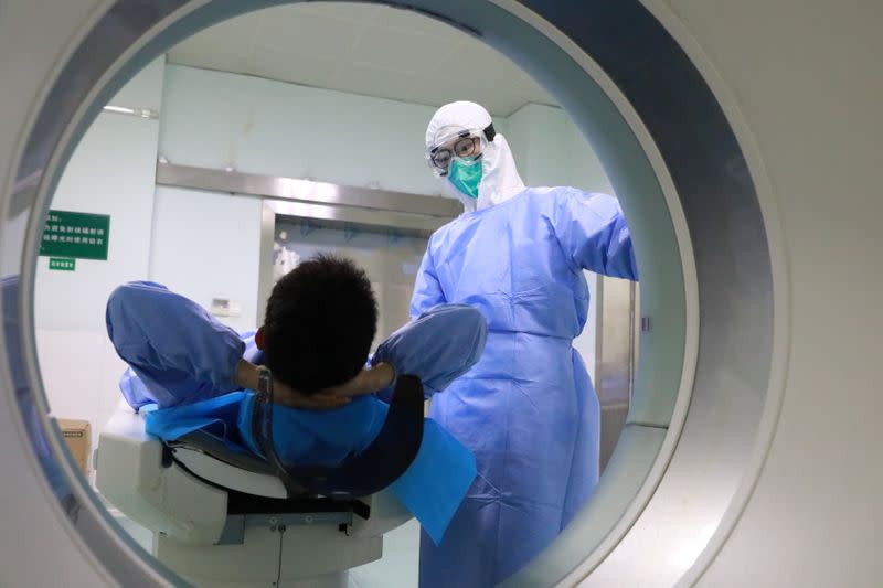 Medical worker helps a patient with CT scan at the Zhongnan Hospital of Wuhan University following an outbreak of the new coronavirus in Wuhan