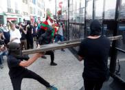 Demonstrators use a part of a barricade to attack the police blockade during a protest against G7 summit, in Bayonne