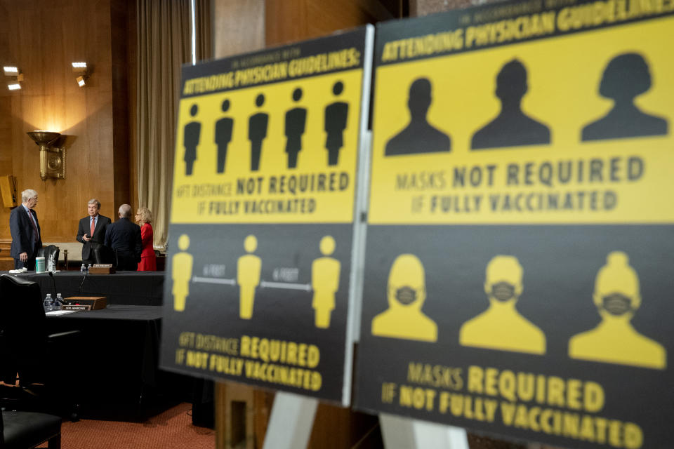 Signs requiring masks if not vaccinated against COVID-19 are displayed as National Institutes of Health Director Francis Collins, Sen. Roy Blunt, R-Mo., Dr. Anthony Fauci, director of the National Institute of Allergy and Infectious Diseases, and Diana Bianchi, director of the Eunice Kennedy Shriver National Institute of Child Health and Human Development, speak after a Senate Appropriations Subcommittee looking into the budget estimates for National Institute of Health (NIH) and the state of medical research, Wednesday, May 26, 2021, on Capitol Hill in Washington. (Stefani Reynolds/Pool via AP)