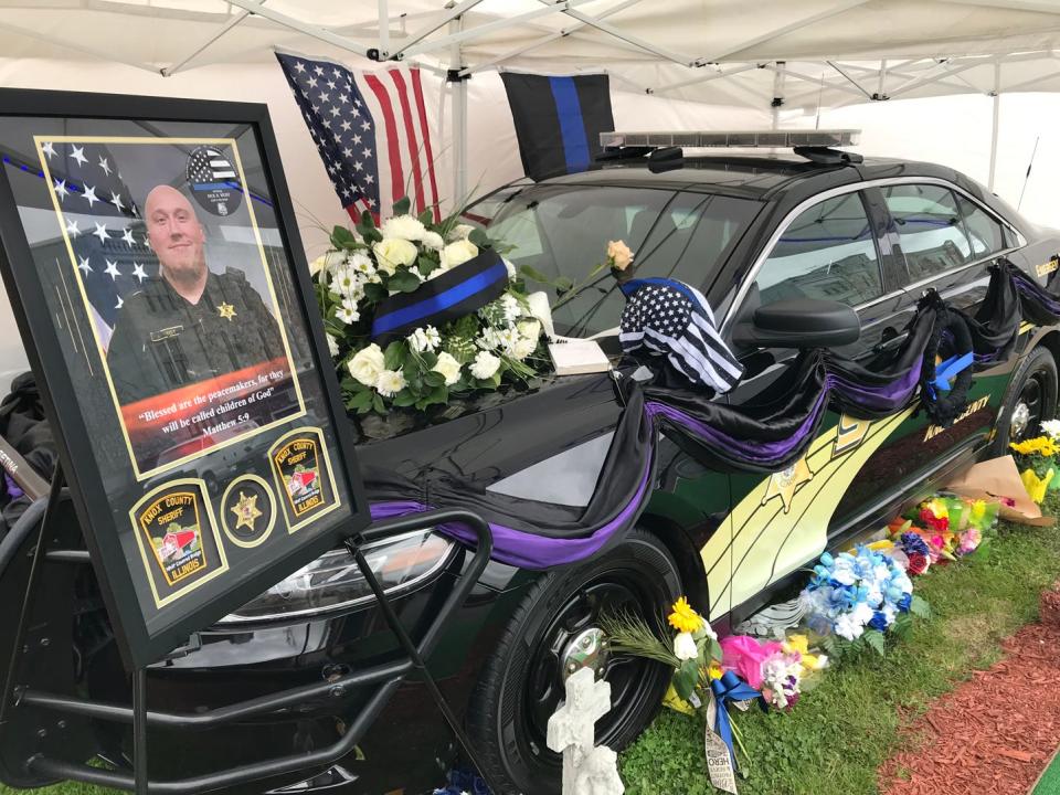 The police car of Knox County Sheriff's Deputy Nicholas Weist is displayed in front of the office at 152 S Kellogg St. in Galesburg, where people paying their respects have left flowers. Weist was killed Friday when he was struck by a vehicle that was fleeing police.