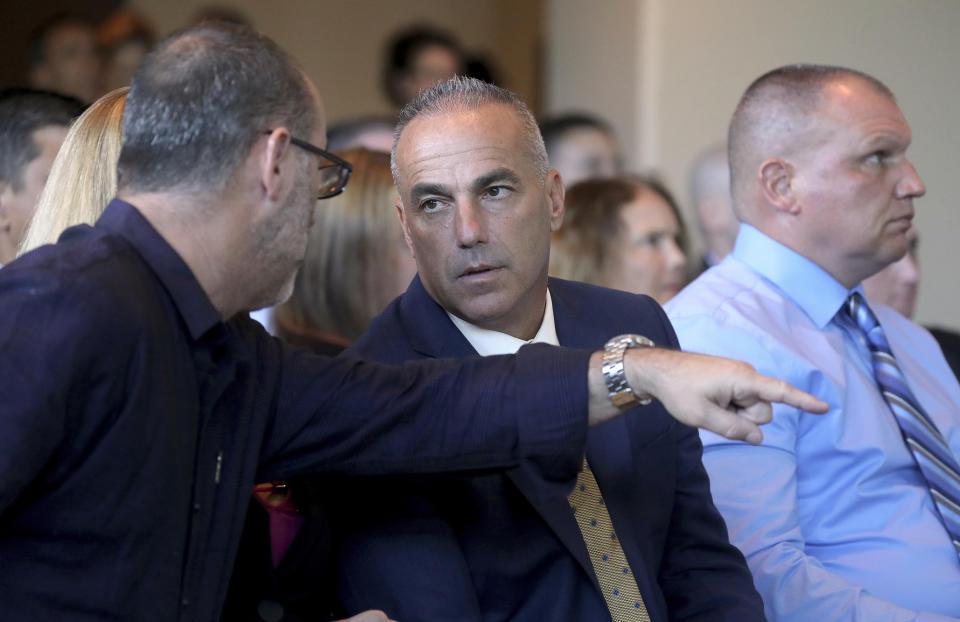 FILE - In this Nov. 15, 2018, file photo, Andrew Pollack, center, the father of Meadow Pollack talk during the Marjory Stoneman Douglas High School Public Safety Commission meeting in Sunrise, Fla. Pollack, whose 18-year-old daughter Meadow died in the shooting, became the most outspoken critic of school and law enforcement officials among the victims' parents and a force in Florida conservative politics. (Mike Stocker/South Florida Sun-Sentinel via AP, Pool, FIle)