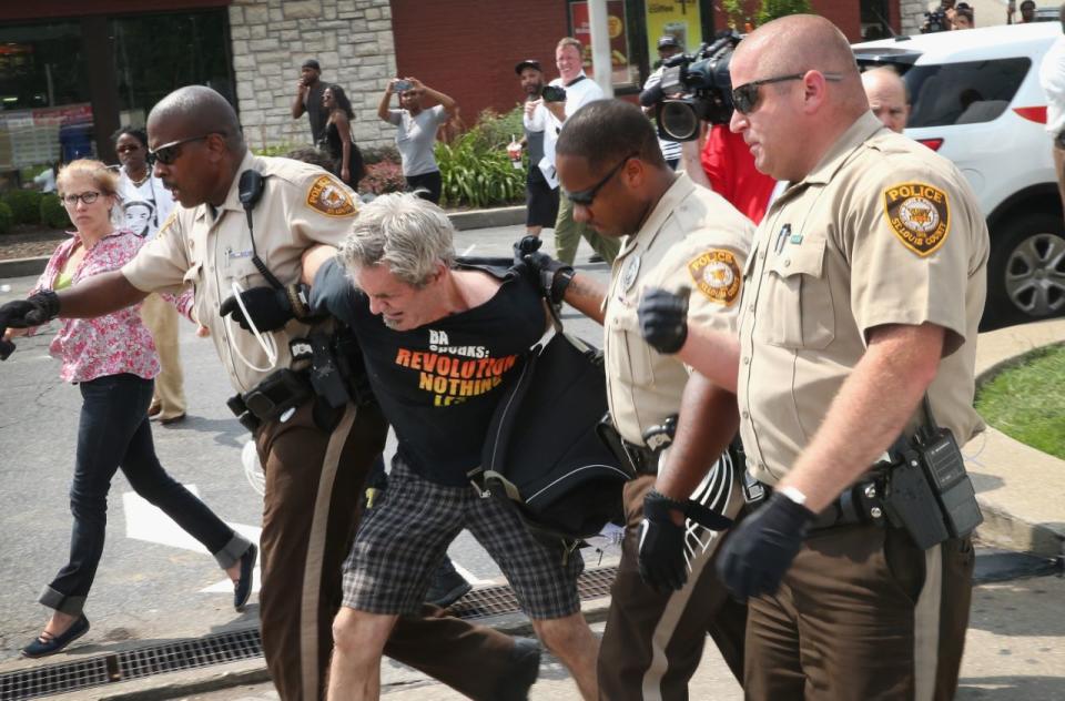 <p>Police arrest a demonstrator, on August 18, 2014 in Ferguson, Missouri protesting the killing of teenager Michael Brown . After a protest the day before ended with a barrage of tear gas and gunfire, Missouri Governor Jay Nixon activated the national guard to help with security. Brown was shot and killed by a Ferguson police officer on August 9. Despite the Brown family’s continued call for peaceful demonstrations, violent protests have erupted nearly every night in Ferguson since his death. (Scott Olson/Getty Images) </p>