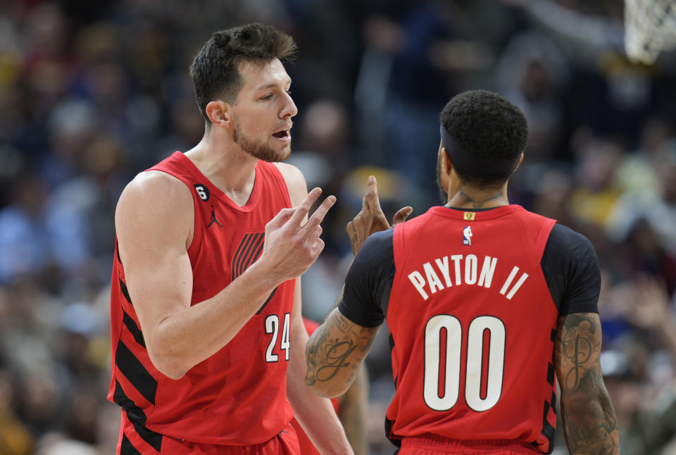 Portland Trail Blazers forward Drew Eubanks, left, talks with guard Gary Payton II during the second half of the team's NBA basketball game against the Denver Nuggets on Tuesday, Jan. 17, 2023, in Denver. (AP Photo/David Zalubowski)