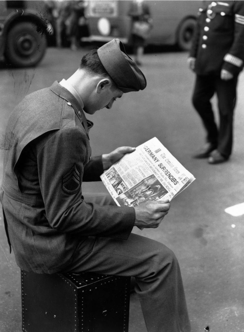 <p>While stationed in London, England an American solider sits down to read the day's paper headlined, "Germany Surrenders."</p>