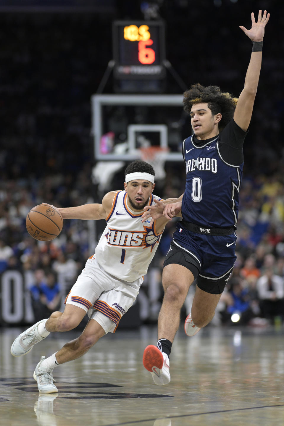 Phoenix Suns guard Devin Booker (1) is defended by Orlando Magic guard Anthony Black (0) during the second half of an NBA basketball game, Sunday, Jan. 28, 2024, in Orlando, Fla. (AP Photo/Phelan M. Ebenhack)