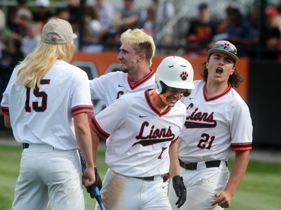 Liberty Union;s John Edwards is congratulated by teammates Jon Wheeler, left, Jacob Miller and Bobby Savage after scoring the tying run during the fourth inning of a 2-1 win against West Lafayette Ridgewood in a Division III regional semifinal on Thursday at Mount Vernon High School.