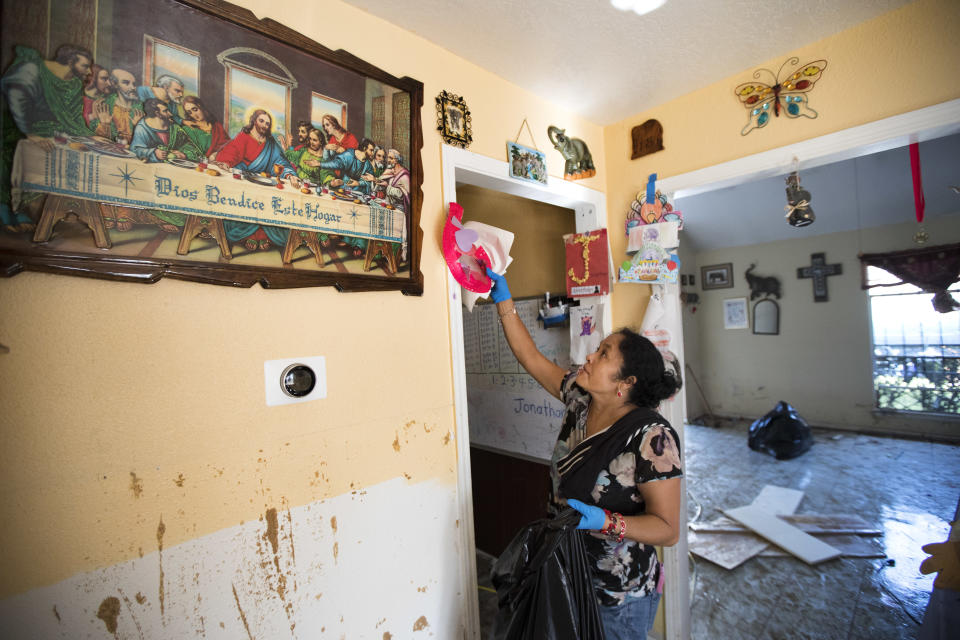 <p>Alma Castenda pulls her children’s artwork off the walls as she cleans up her flood-damaged home in the Verde Forest subdivision of Houston in the aftermath of Tropical Storm Harvey on Thursday, Aug. 31, 2017. (Photo: Brett Coomer/Houston Chronicle via AP) </p>