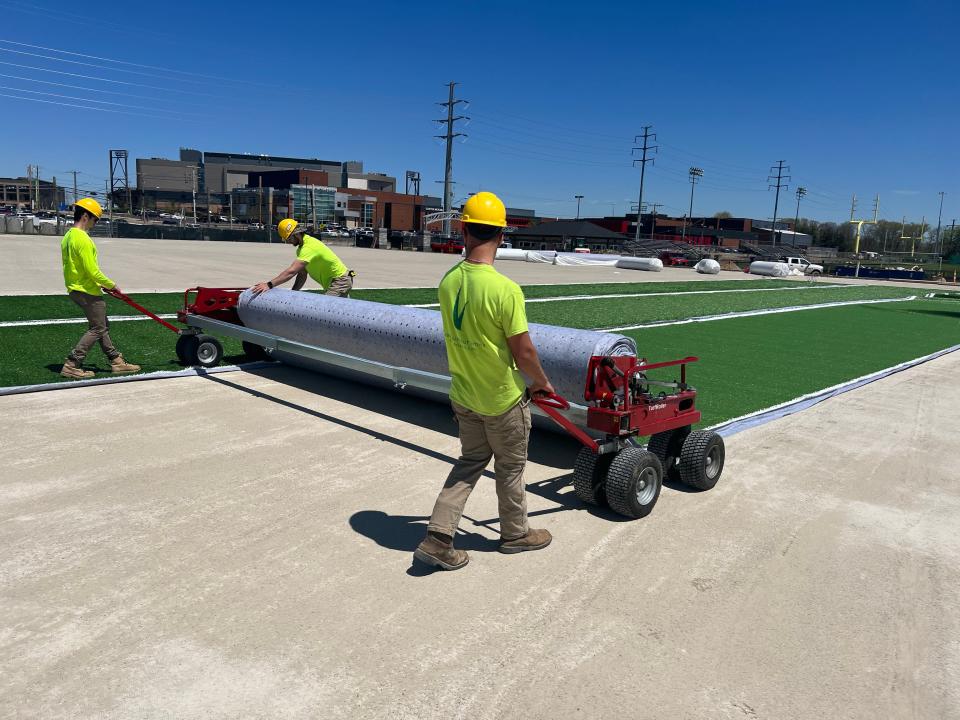 Employees with ForeverLawn install artificial surface at the youth fields under construction at Hall of Fame Village. ForeverLawn is one of seven companies receiving the Business Excellence Award this Thursday from the Canton Regional Chamber of Commerce. (Submitted photo)