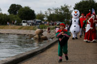 <p>A child dressed as an elf walks along the waterfront during an event in the World Santa Claus Congress, an annual event held every summer in Copenhagen, Denmark, July 23, 2018. (Photo: Andrew Kelly/Reuters) </p>