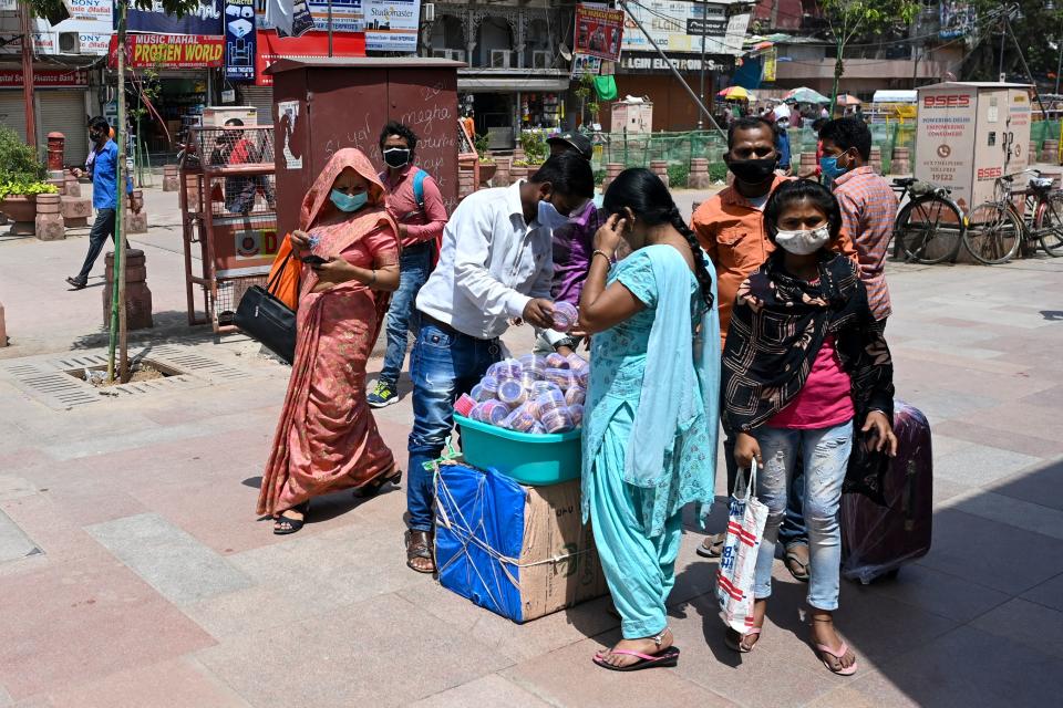 A vendor selling bangles attends a customer in New Delhi on April 19, 2021, as India's capital will impose a week-long lockdown from tonight, officials said, while the megacity struggles to contain a huge surge in Covid-19 cases with hospitals running out of beds and oxygen supplies low. (Photo by Sajjad HUSSAIN / AFP) (Photo by SAJJAD HUSSAIN/AFP via Getty Images)