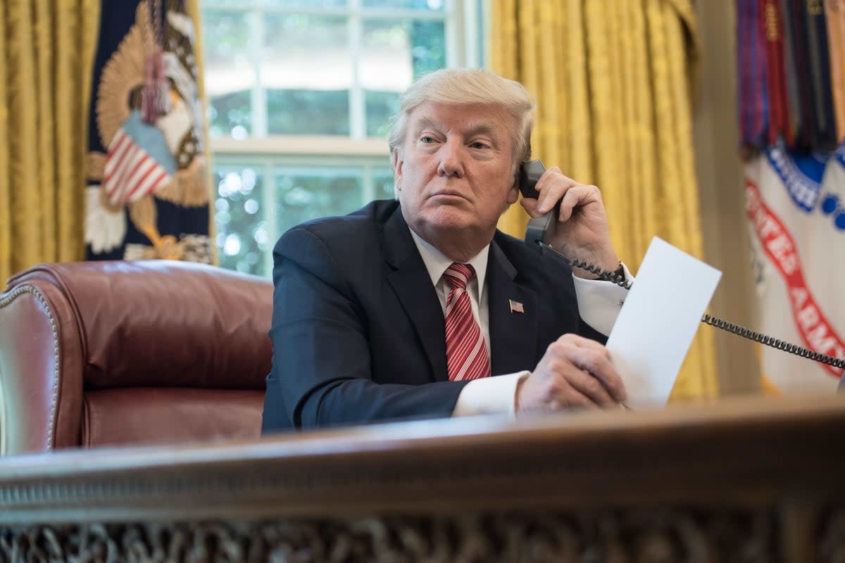 Donald Trump putting in a call from the Resolute Desk (AFP/Getty)