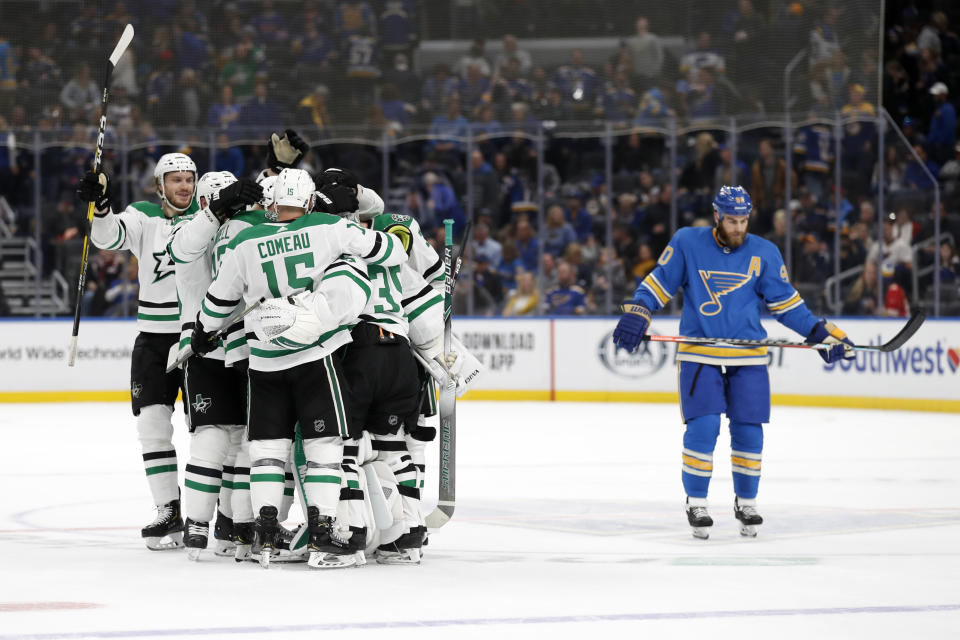 Members of the Dallas Stars celebrate as St. Louis Blues' Ryan O'Reilly, right, skates past following an NHL hockey game Saturday, Feb. 8, 2020, in St. Louis. The Stars won 3-2 in overtime. (AP Photo/Jeff Roberson)