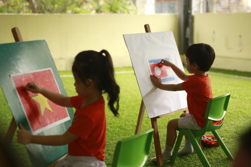 In this Thursday, Feb. 21, 2019, photo, children draw flags of Vietnam, left, and North Korea at Vietnam-Korea Friendship Kindergarten in Hanoi, Vietnam. Children at the kindergarten have been practicing singing and dancing, hoping to show off their talents to North Korean leader Kim Jong Un when he comes to town this week for his second summit meeting with U.S. President Donald Trump. (AP Photo/Hau Dinh)