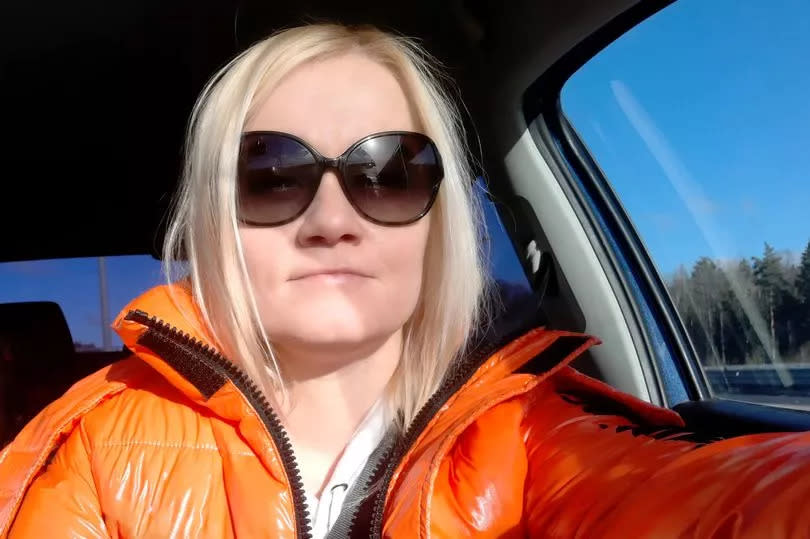 Girl with white hair in sunglasses behind the wheel of a car. Portrait.