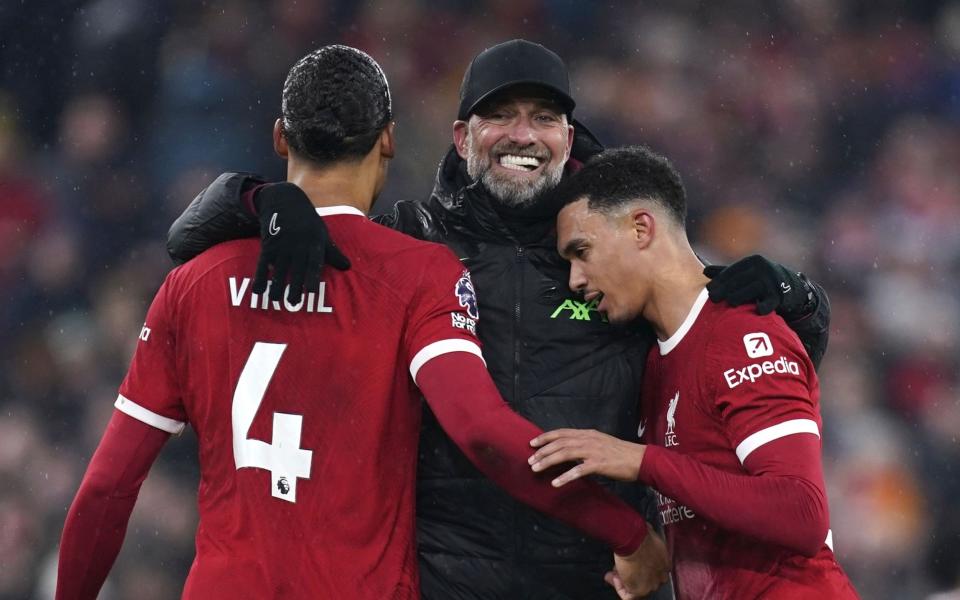 Liverpool manager Juergen Klopp (C) celebrates with his players Virgil van Dijk (L) and Trent Alexander-Arnold