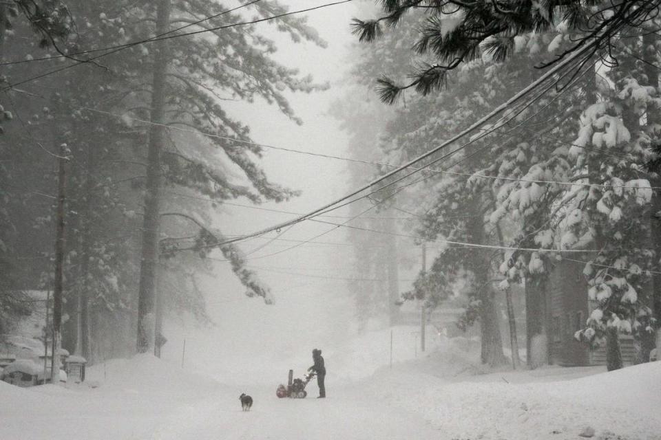 A person tries to clear snow from a road during a storm, Saturday, March 2, 2024, in Truckee, Calif. A powerful blizzard howled Saturday in the Sierra Nevada as the biggest storm of the season shut down a long stretch of Interstate 80 in California and gusty winds and heavy rain hit lower elevations, leaving tens of thousands of homes without power.