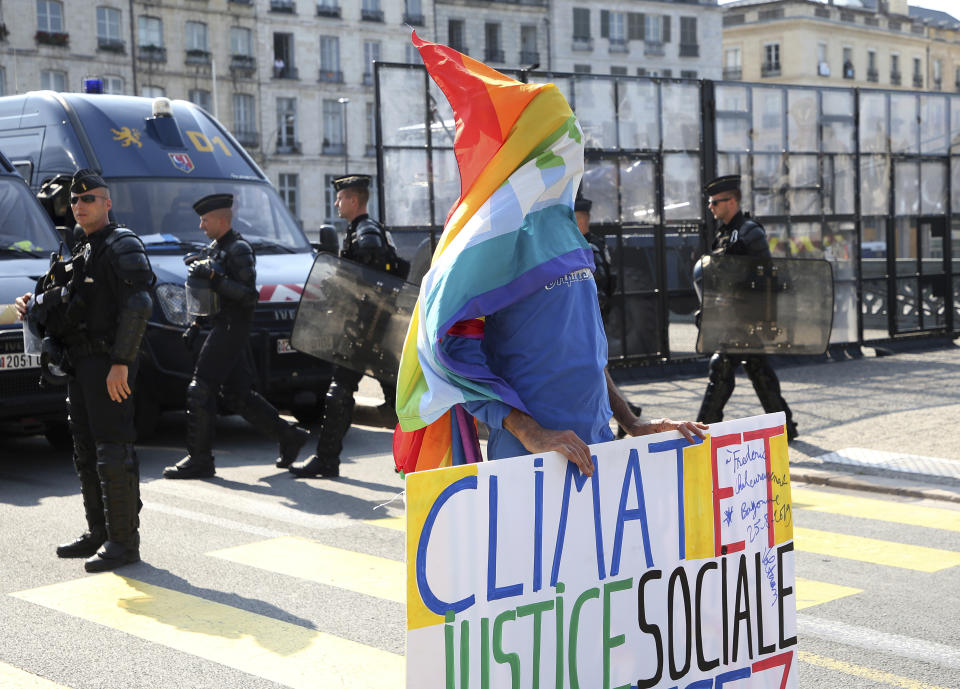 A protestor stands in front of police officers in Bayonne, France Sunday, Aug. 25, 2019. Demonstrators were gathering again late afternoon in protest of the G-7 summit taking place in nearby Biarritz. (AP Photo/Bob Edme)