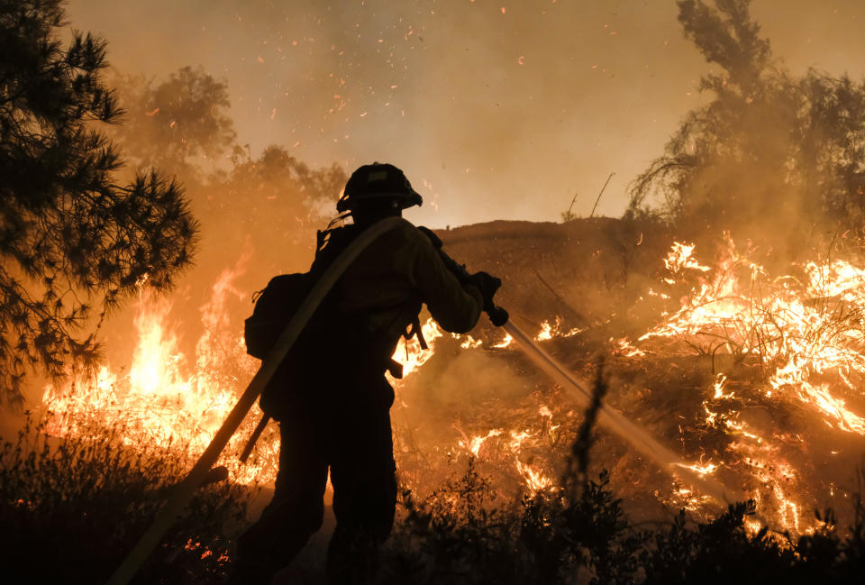 <p>A firefighter battles the Holy Fire burning in the Cleveland National Forest along a hillside at Temescal Valley in Corona, Calif., Thursday, Aug. 9, 2018. (Photo: Ringo H.W. Chiu/AP) </p>