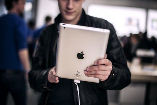 A customer test an iPad at a new Apple store in Lyon, France, on April 4. Apple said it had raked in a profit of $11.6 billion in the first three months of the year driven by record sales of iPhones and iPad tablet computers