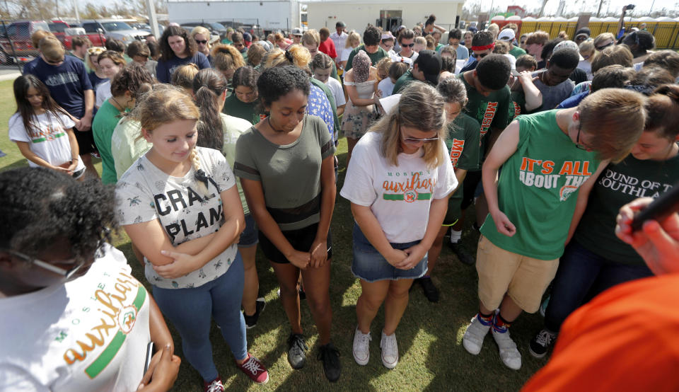 Band members from several areas schools, who came together to play jointly at a football game between Mosley High, which suffered extensive damage from Hurricane Michael, and visiting Pensacola High, pray during halftime in Panama City, Fla., Saturday, Oct. 20, 2018. (AP Photo/Gerald Herbert)