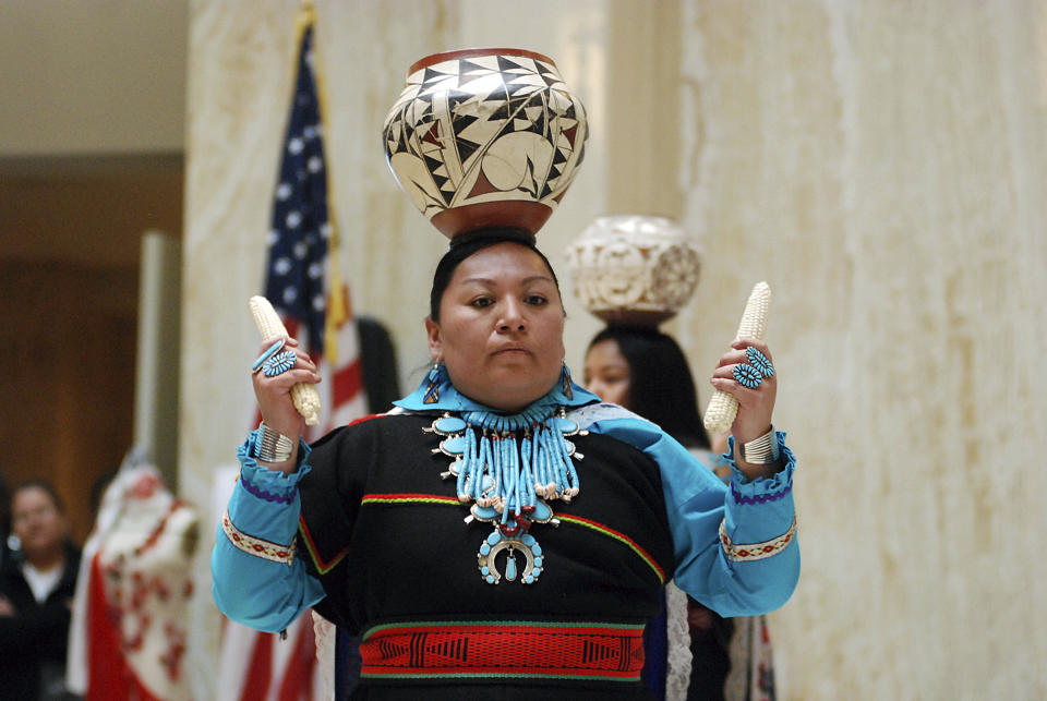 FILE - In this Feb. 1, 2019 file photo, Calela Lamy of Zuni Pueblo performs the pottery dance at the New Mexico Statehouse in Santa Fe, N.M. before the state adopted it's first Indigenous Peoples' Day. A handful of states, including New Mexico and Maine, are celebrating their first Indigenous Peoples' Day as part of a trend to move away from a day honoring Christopher Columbus. (AP Photo/Morgan Lee, File)