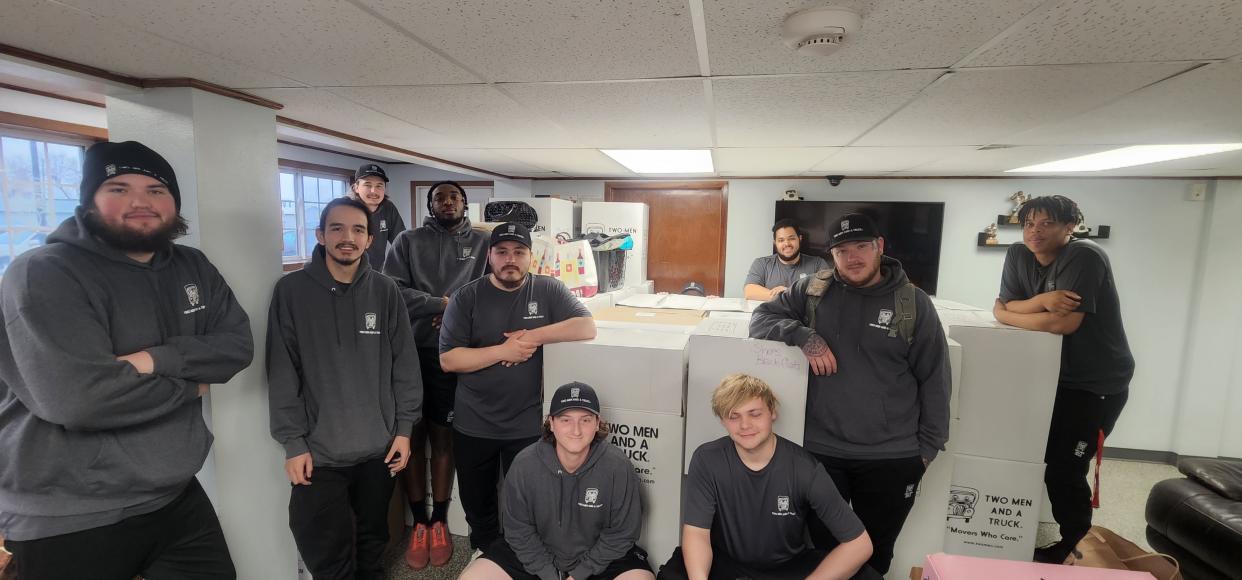 Moving crews at Two Men and a Truck pose for a picture with boxes full of donated clothes. The 2022 Movers for Mom clothing drive brought in a record 26,000 items.