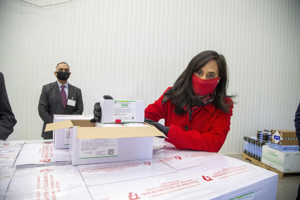 Anita Anand, Canada's Minister of Public Services and Procurement, poses for a photo with some of the first 500,000 of the two million AstraZeneca COVID-19 vaccine doses that Canada has secured through a deal with the Serum Institute of India in partnership with Verity Pharma, Wednesday, March 3, 2021, at a facility in Milton, Ontario. (Carlos Osorio/Pool Photo via AP)