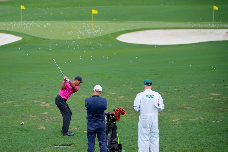 Tiger Woods hits balls at the practice facility during the first round of The Masters.