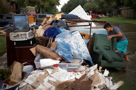Isaac Zermeno discard furniture from the house of a neighbor who was left flooded from Tropical Storm Harvey in Houston, Texas, U.S. September 3, 2017. REUTERS/Adrees Latif