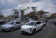 An electric car drives past other vehicles in Kathmandu, Nepal, Wednesday, May 22, 2024. Nepal’s imports of EVs have doubled in each of the past two years, allowing the country to save its precious foreign currency instead of spending it on imports of oil and other fuels. (AP Photo/Niranjan Shrestha)