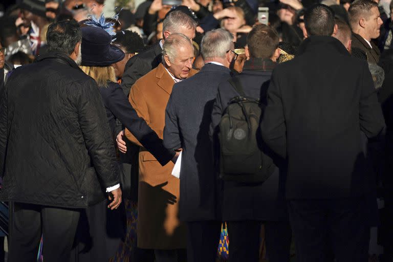 Close-protection officers usher Britain's King Charles III out of the way as he was meeting members of the public during a visit to Luton, England, Tuesday Dec. 6, 2022. A man has been arrested on suspicion of assault after an egg was allegedly hurled towards King Charles III during a visit to the town center. (Yui Mok/PA via AP)