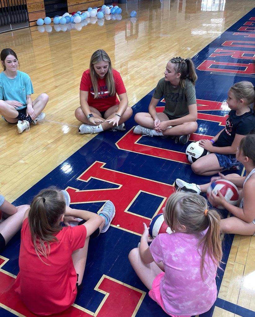 Grade-school kids circle with BNL players to discuss volleyball fundamentals this week at BNL Stars Camp.