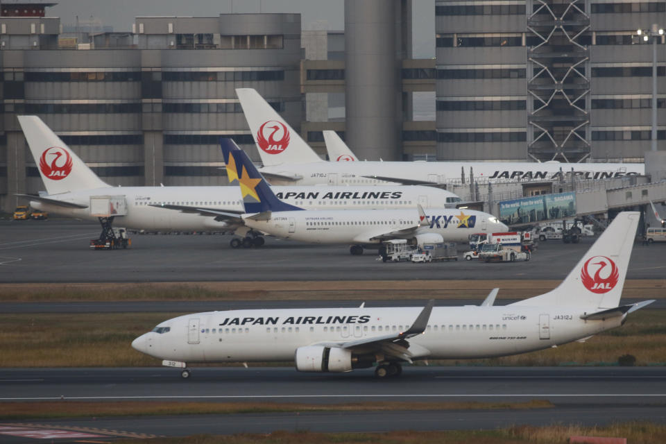 FILE - Japan Airlines planes sit on the tarmac at Haneda international airport in Tokyo, Monday, Nov. 29, 2021. NHK TV said Wednesday, Dec. 1, that Japan will suspend new reservations on all incoming flights for a month to guard against new virus variant. (AP Photo/Koji Sasahara, File)