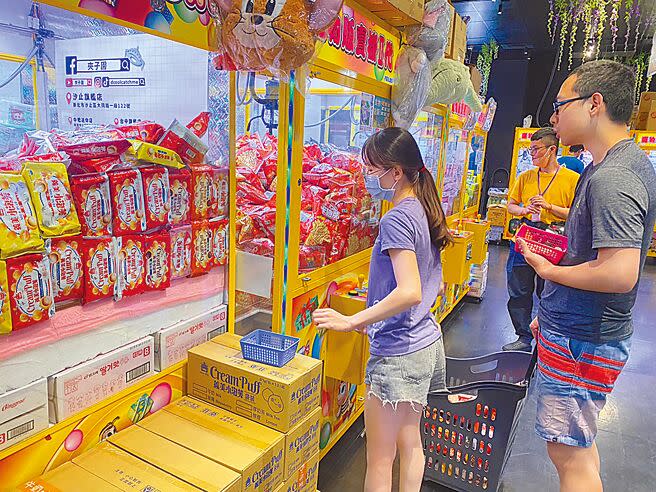 零食夾娃娃機近來成為一股潮流，天氣炙熱不免讓顧客擔心機台內堆成小山的餅乾、泡麵、鋁箔飲料等是否有食安問題。（高鈞麟攝）