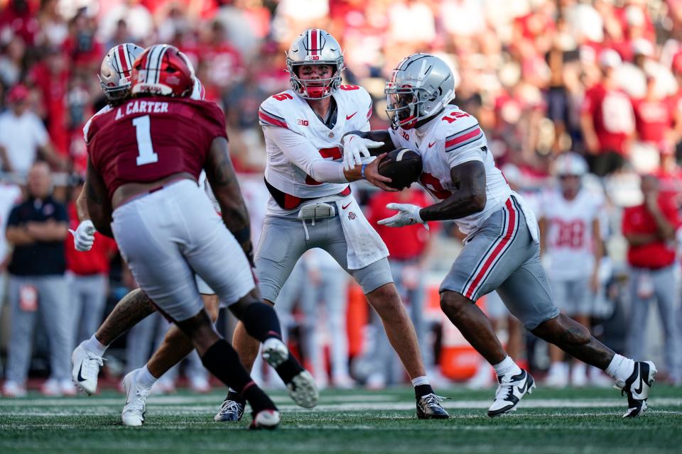 Ohio State quarterback Kyle McCord hands off to running back Chip Trayanum during the second half of the Buckeyes' win at Memorial Stadium.