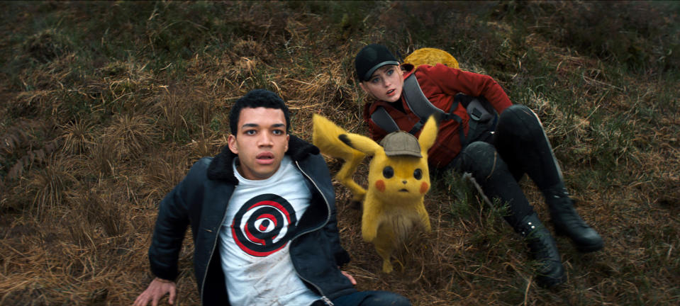 This image released by Warner Bros. Pictures shows Justice Smith, left, the character Detective Pikachu, voiced by Ryan Reynolds, and Kathryn Newton in a scene from "Pokemon Detective Pikachu." (Warner Bros. Pictures via AP)