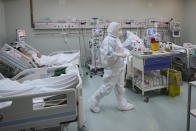 Medical staff attend to patients at the COVID-19 ICU unit of the Marius Nasta National Pneumology Institute in Bucharest, Romania, Thursday, Sept. 23, 2021. Daily new coronavirus infections in Romania, a country of 19 million, have grown exponentially over the last month, while vaccine uptake has declined to worrying lows. Government data shows that 91.5% of COVID-19 deaths in Romania between Sept. 18-23 were people who had not been vaccinated. (AP Photo/Vadim Ghirda)