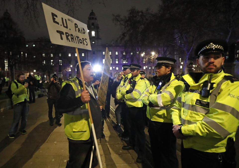 An pro-Brexit demonstrator confronts police officers in Parliament square in London, Tuesday, Jan. 15, 2019. Rival groups of pro-Brexit and pro-EU demonstrators are rallying outside Britain's Parliament ahead of Tuesday's historic vote on a divorce deal with the European Union. (AP Photo/Frank Augstein)